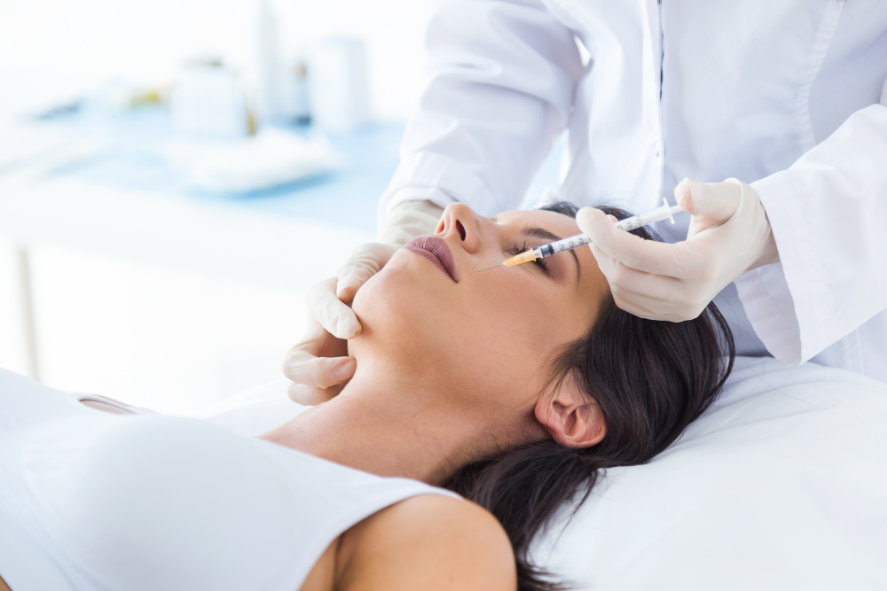 beautiful young woman getting botox cosmetic injection her face