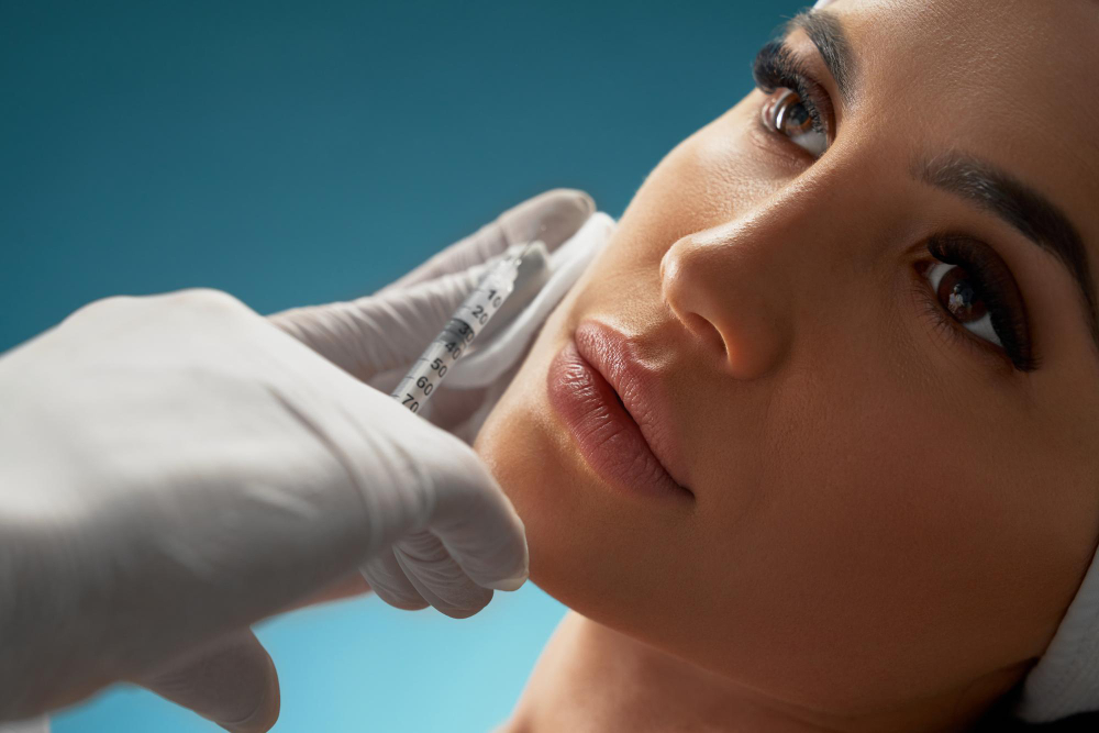 cosmetologist using syringe correct female face